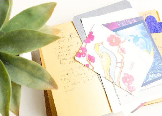 Colorful spirit cards sitting on top of a journal.