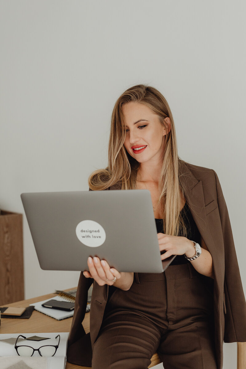 kaboompics_young-entrepreneur-dressed-in-brown-suit-holds-laptop-27939