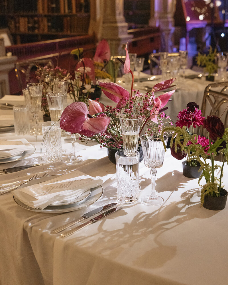 Serpentine tables with bright pink florals at the George Peabody Library