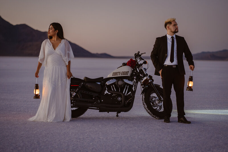Couple elopes on the Bonneville Salt Flats in Utah, with their motorcycle and lanterns.