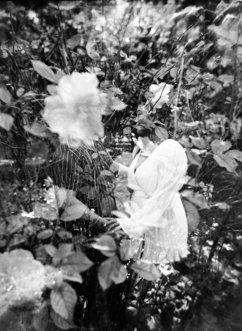 A dreamy, abstract composition featuring a double exposure of two people holding hands, overlaid with flowers and foliage. Perfectly capturing the essence of love and nature at Berczy Park in Toronto by engagement film photographer Jennifer van Son.