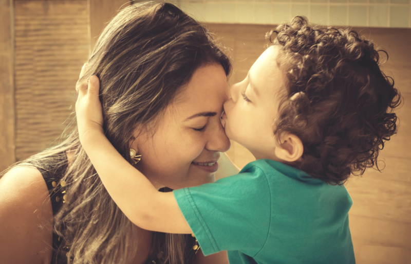 T1D mom receiving a kiss from her young son — symbolizing love, care, and support on the Type 1 Diabetes journey.