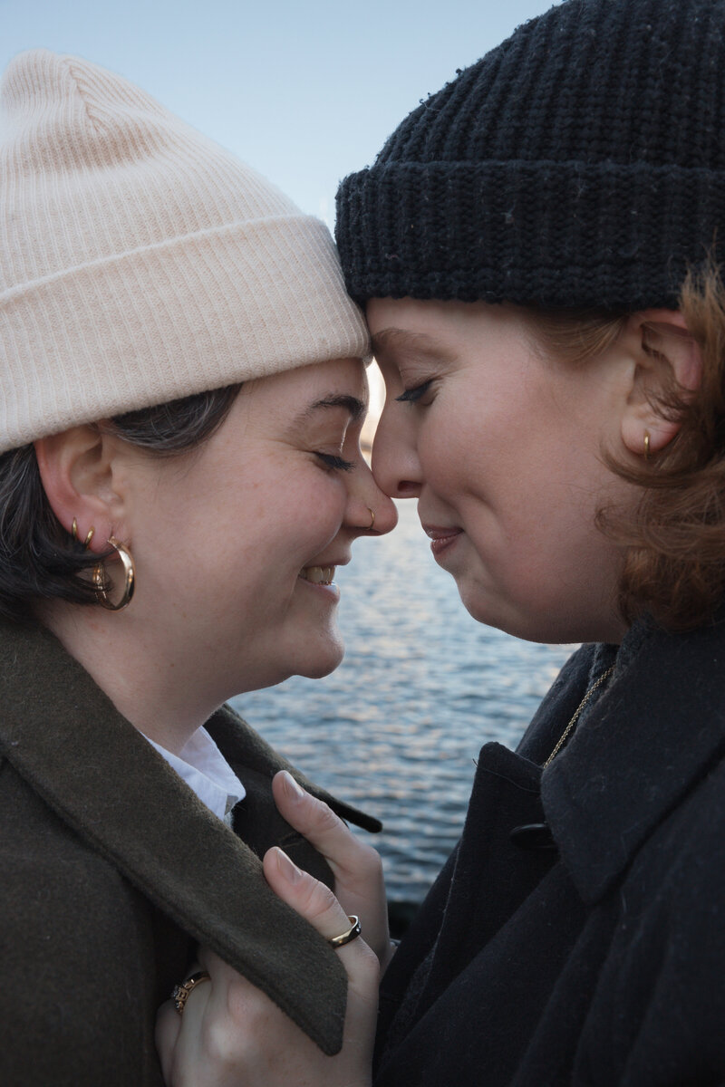 Close-up of a loving couple sharing an intimate moment near the water in DUMBO, NYC, captured by Michelle Salazar Photography.