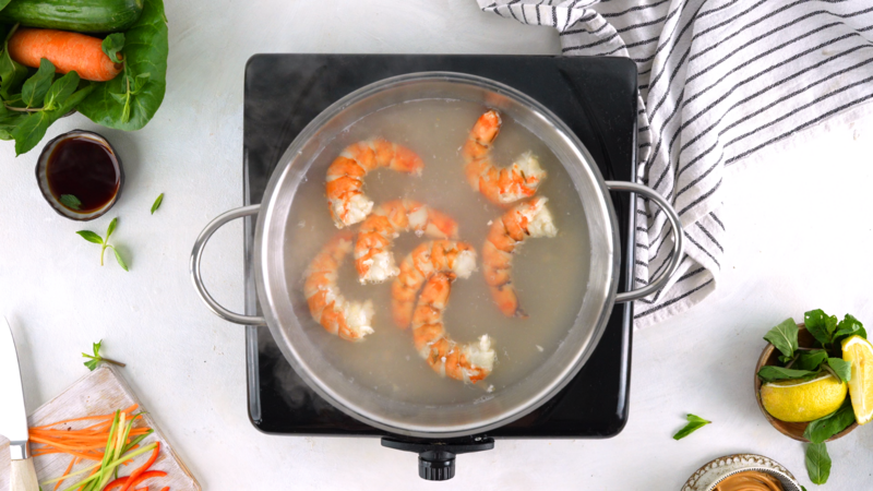 An image of a step in the recipe where the shrimp is cooking on the stove