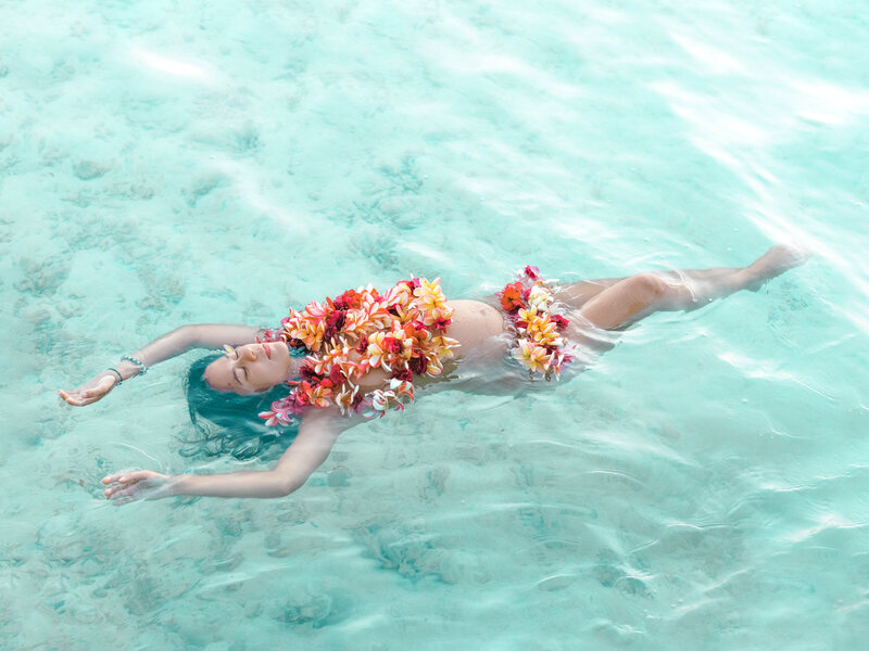 Photo grossesse artistique dans l'eau avec fleurs