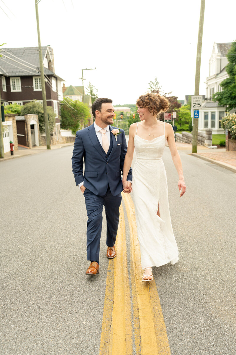 The Groom and Bride walking in the streets holding hands after their intimate elopement ceremony.