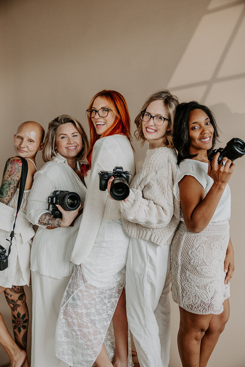 group of female wedding photographers holding their cameras