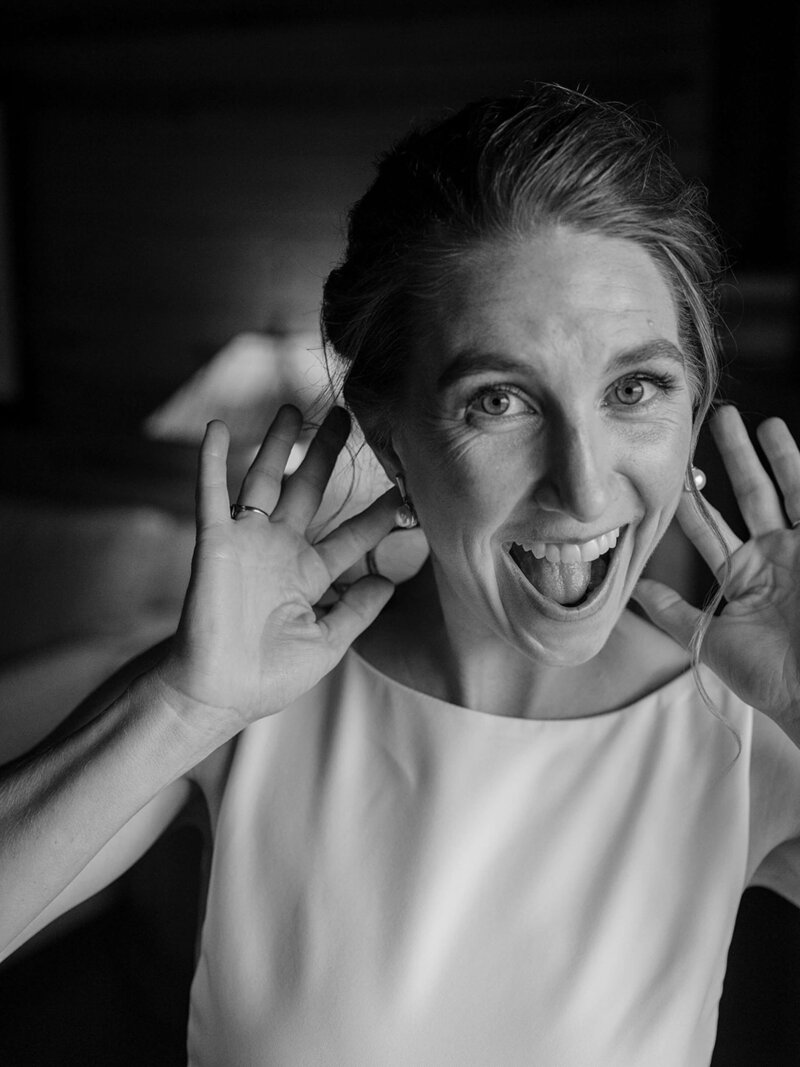 bride smiling happily at the camera while getting ready
