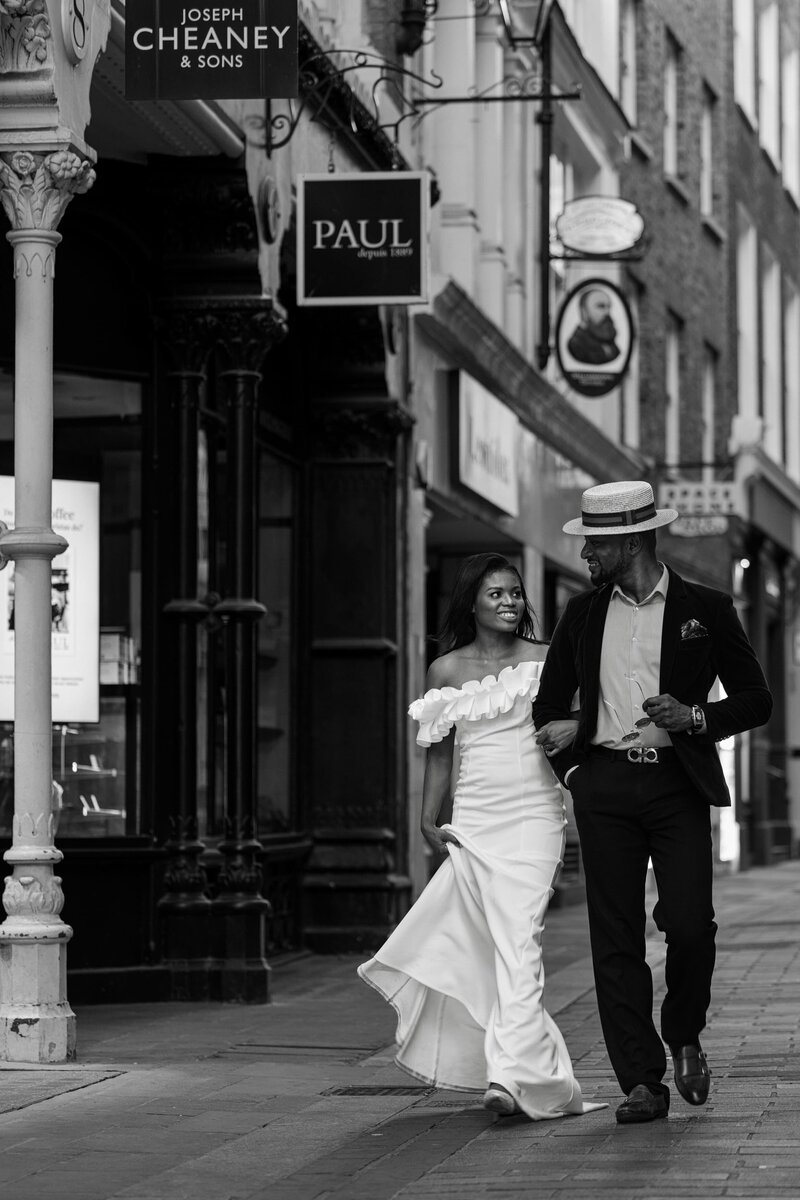 candid photo of a happy couple holding hands walking in the old street of London near St Paul's during their wedding photography