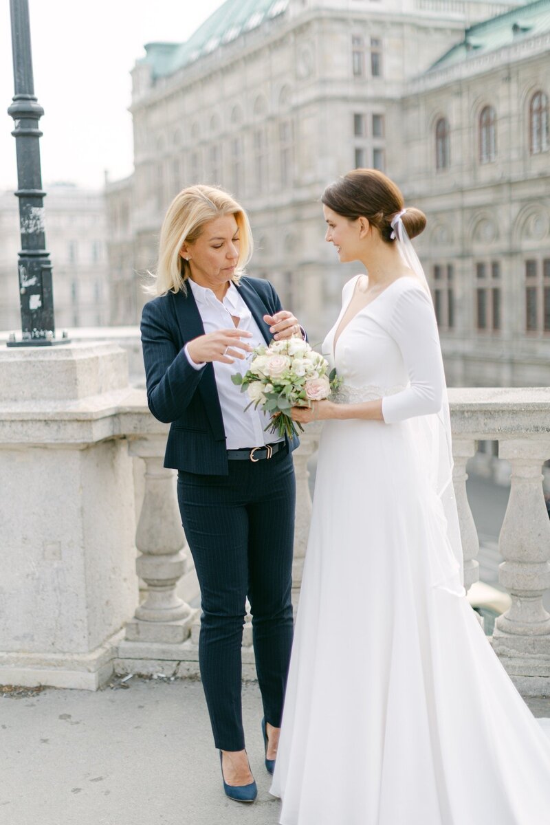 Bride talking to a destination wedding planner of ECLAT Destination Weddings in front of the State Opera in Vienna