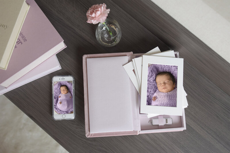 A box of portraits lay open on a table of newborn