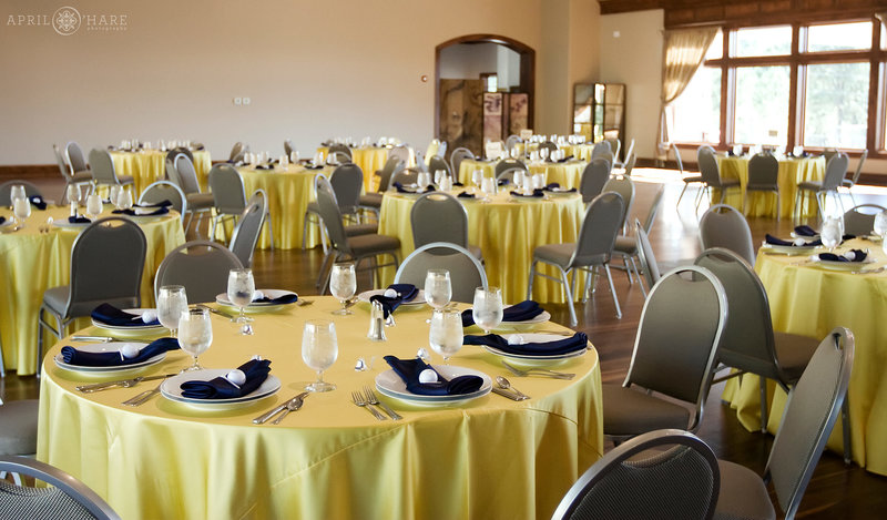 Interior of Cielo at Castle Pines with round tables decorated with yellow tablecloths and navyblue napkins