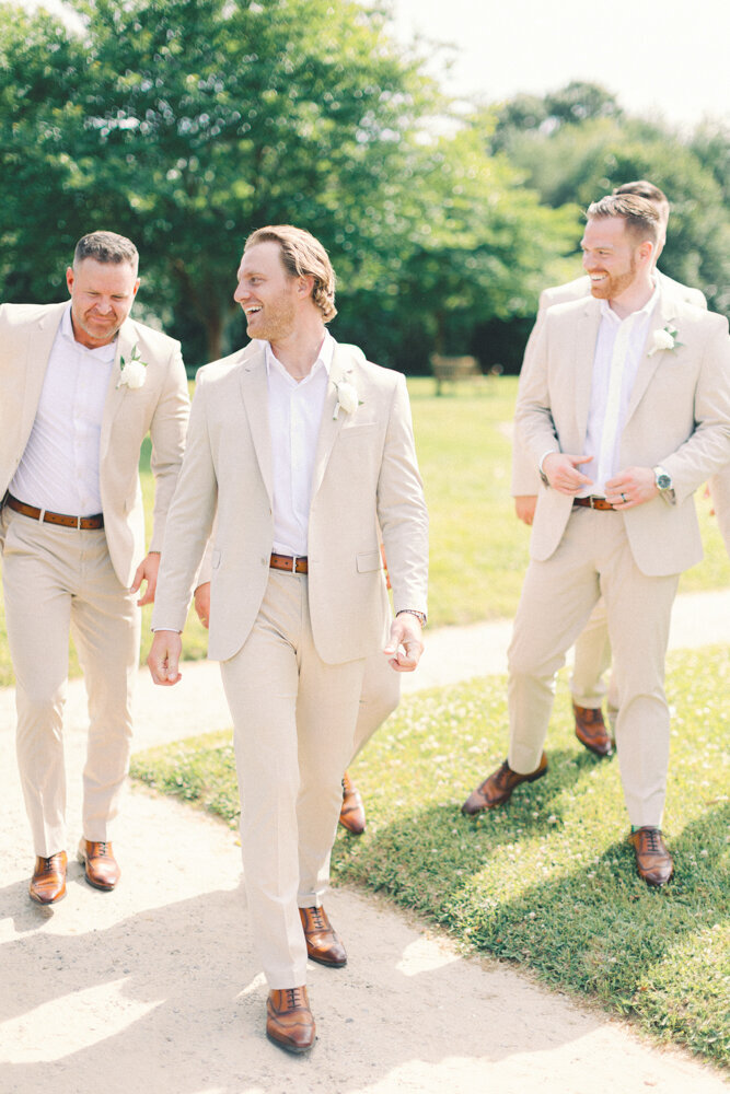 groom and groomsmen walking and smiling