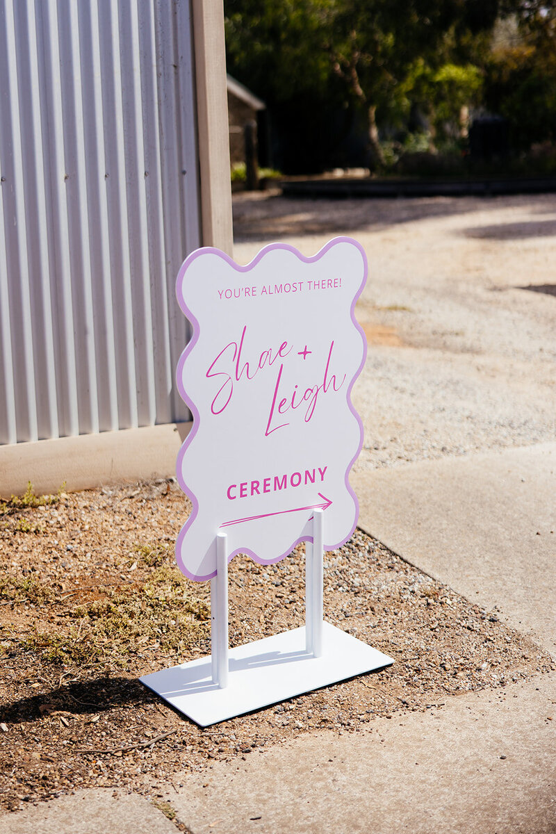 Personalised signage with flower arrangements styled for a wedding ceremony