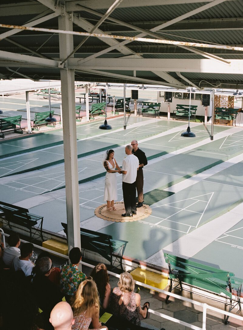 bride and groom on court taken by film wedding photographers Noble Photo Co