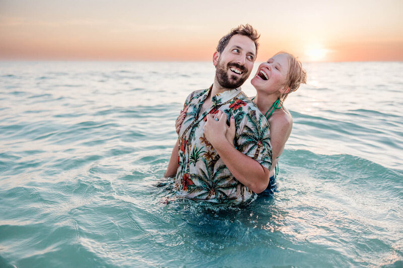 Couples takes photos in the ocean on the gulf coast of Florida