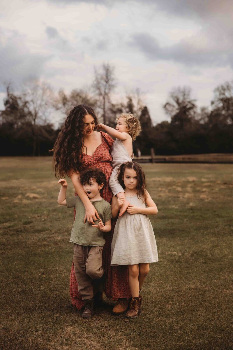 Maria Grace, lifestyle family photographer, posing for a natural self-family-portrait in The Woodlands