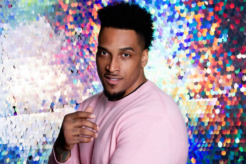 Personal Branding Image Joe Barksdale wearing pink shirt standing in front of iridescent colored wall