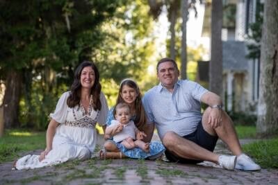 Happy family with baby during outdoor family photography session in St Augustine FL, showcasing professional family portraits
