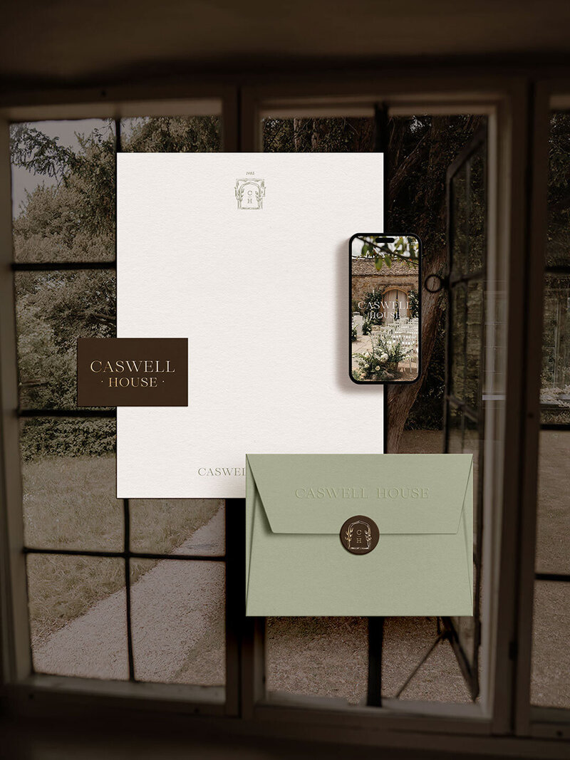 Branded Caswell House stationery suite on a moody wedding photo background
