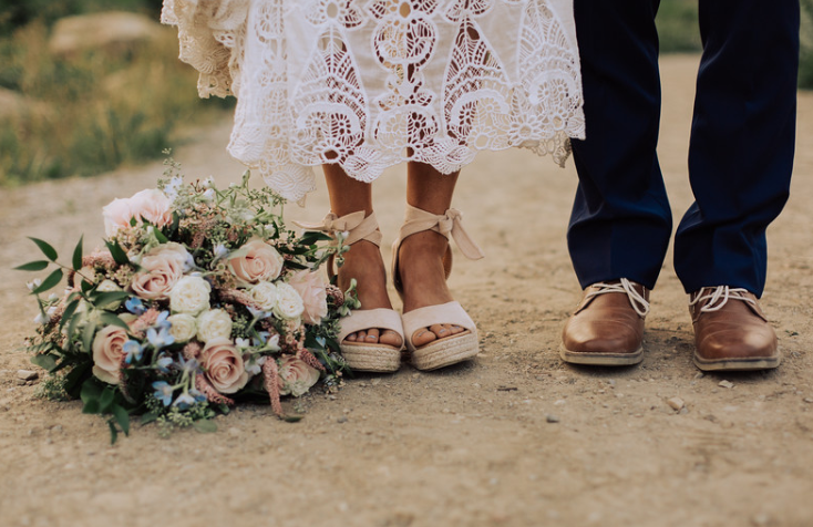 beautiful bouquet at her feet of the bride and grooms feet