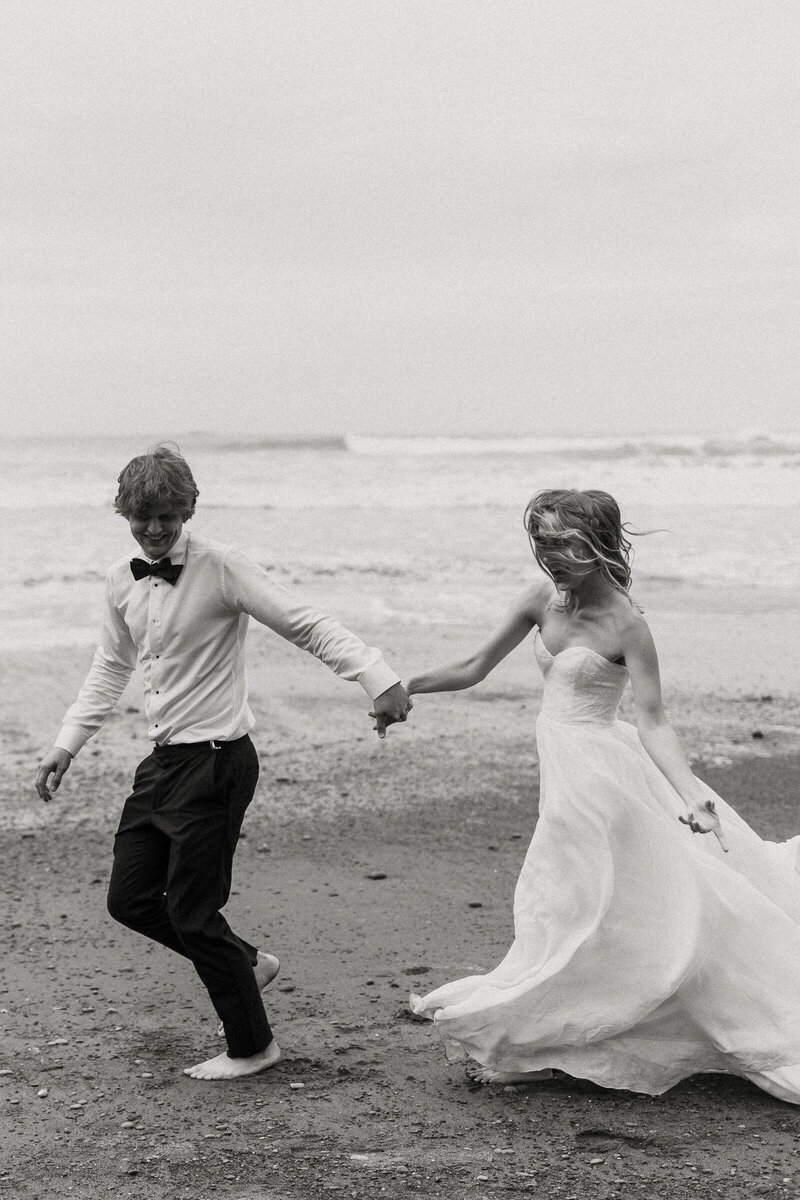 Bride and Groom run along the beach at their Washington elopement.