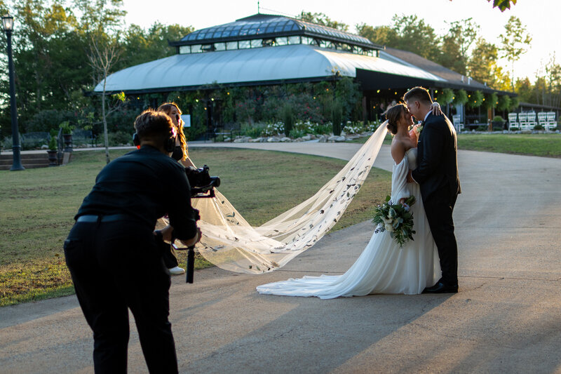 A newlywed couple being recorded by a videographer 