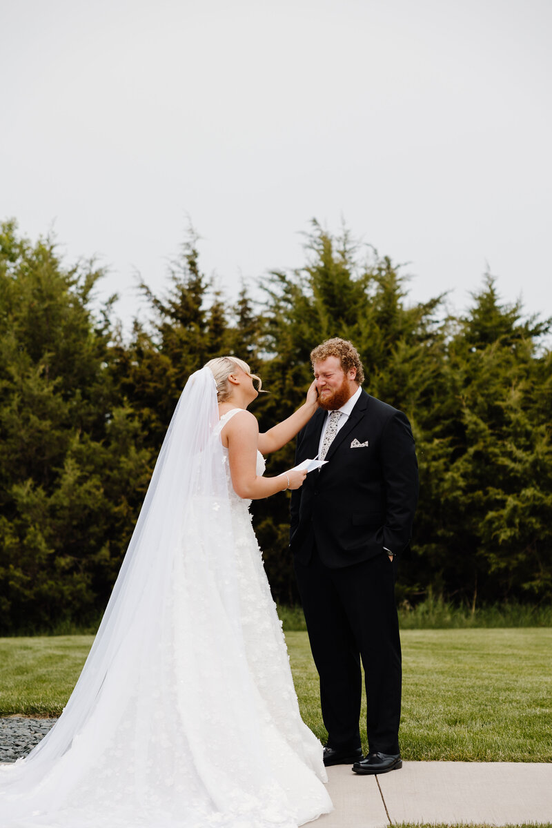 A wedding couple standing on a mountain overlook smiling