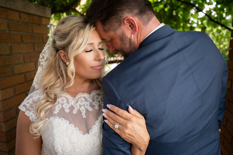 bride and groom hug underneath the bride's veil