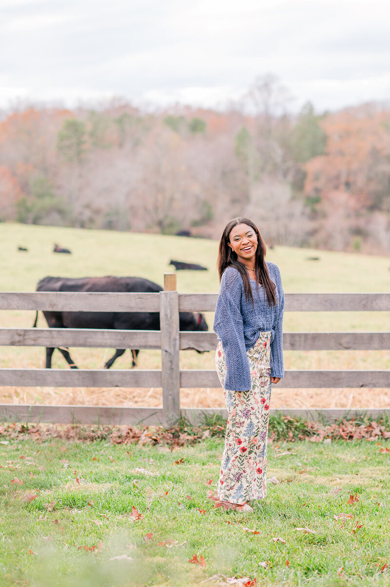 girl smiling with cows in the background