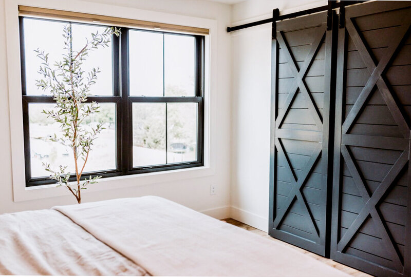 Bed, windows and sliding barn doors in the bedroom of the bridal suite.