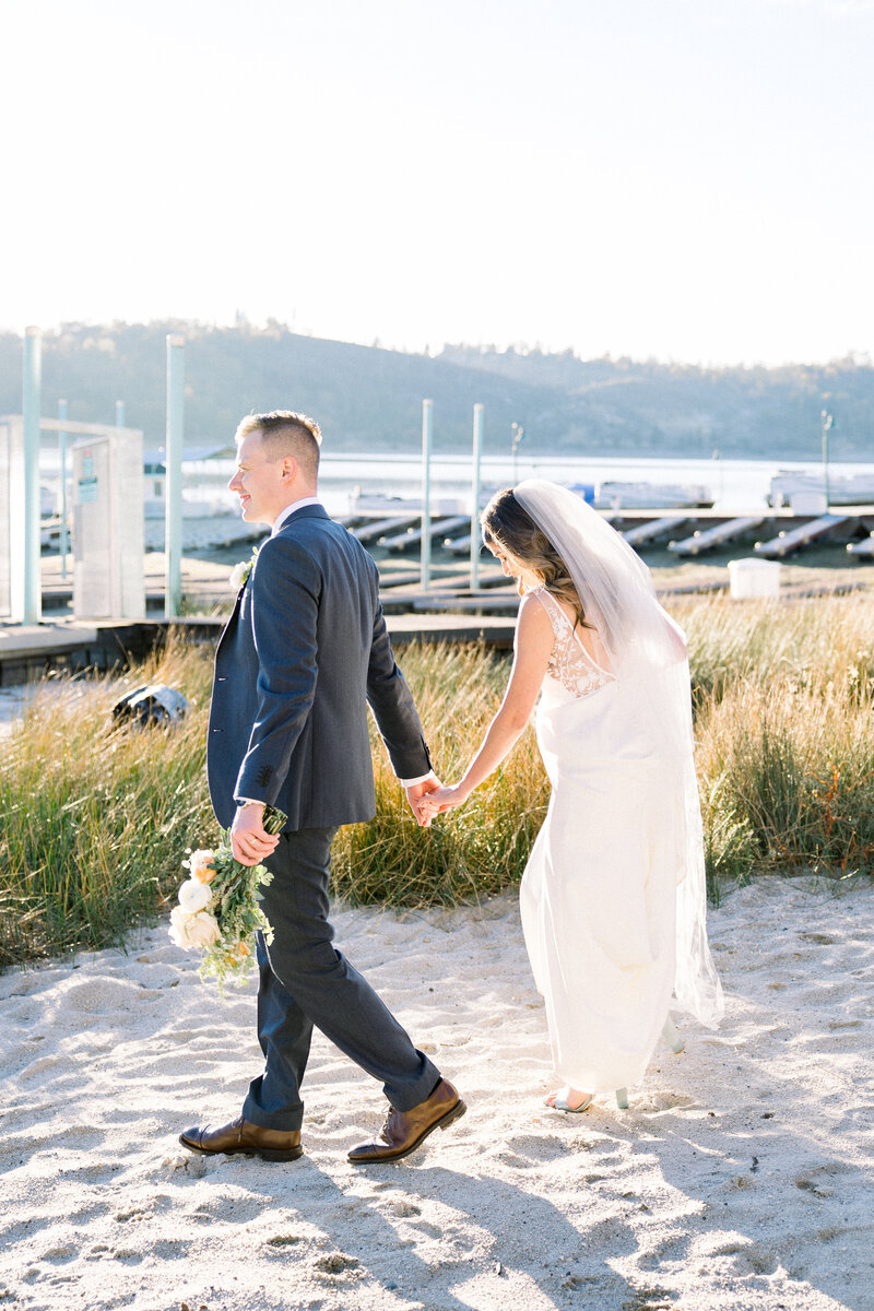 Bride and groom hold hands at their wedding at Wolf Lakes in Fresno