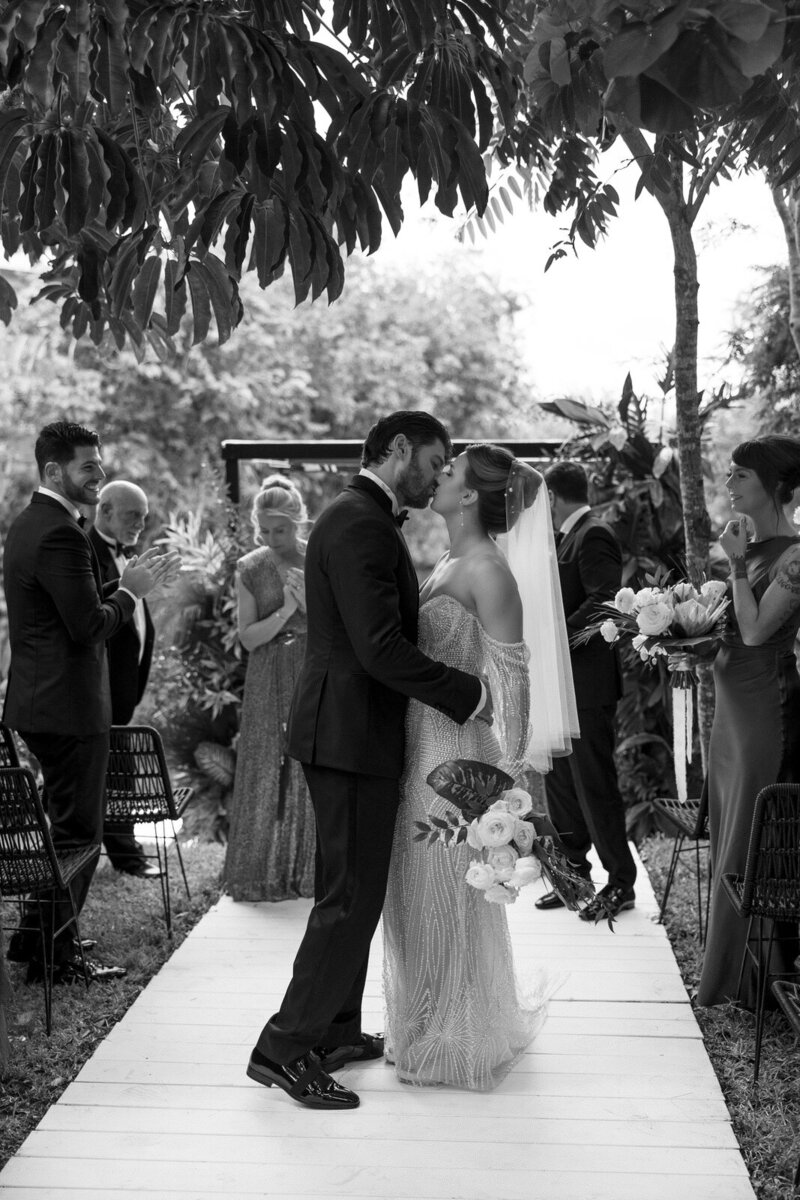 A Bride and Groom kissing walking back up the aisle at their wedding ceremony as husband and wife in Rosewood Mayakoba, Tulum, Mexico, by Andrea-Marie Photography