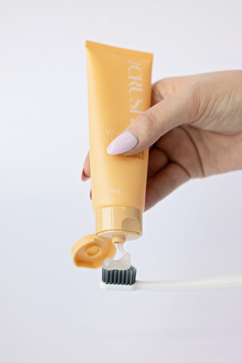 toothpaste being squeezed onto toothbrush