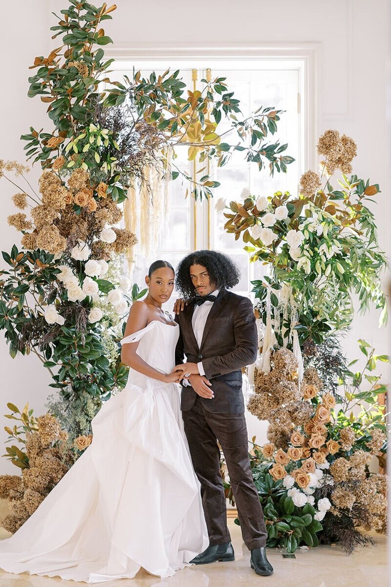 Bride and groom at Raleigh wedding ceremony, surrounded by soft neutral florals and lush greenery.