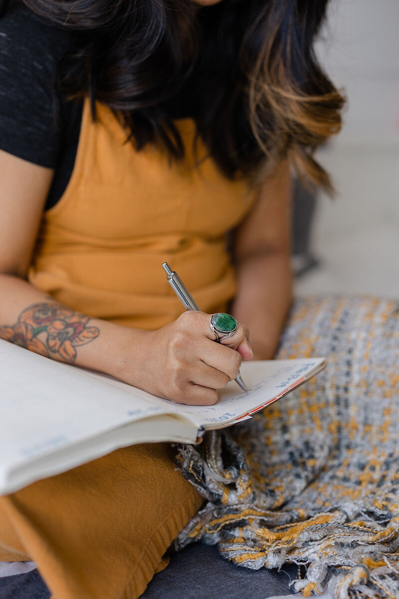 Woman writing on notebook during branding pictures in Ashburn, Virginia