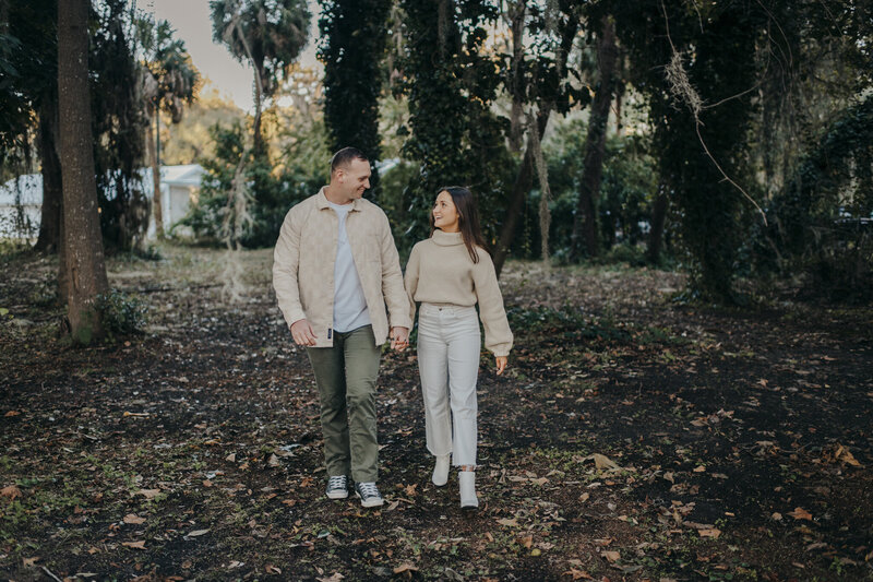 couple walking beneath a tree at hilton head engagement shoot
