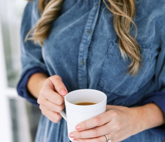 lady in blue dress holding a mug of tea