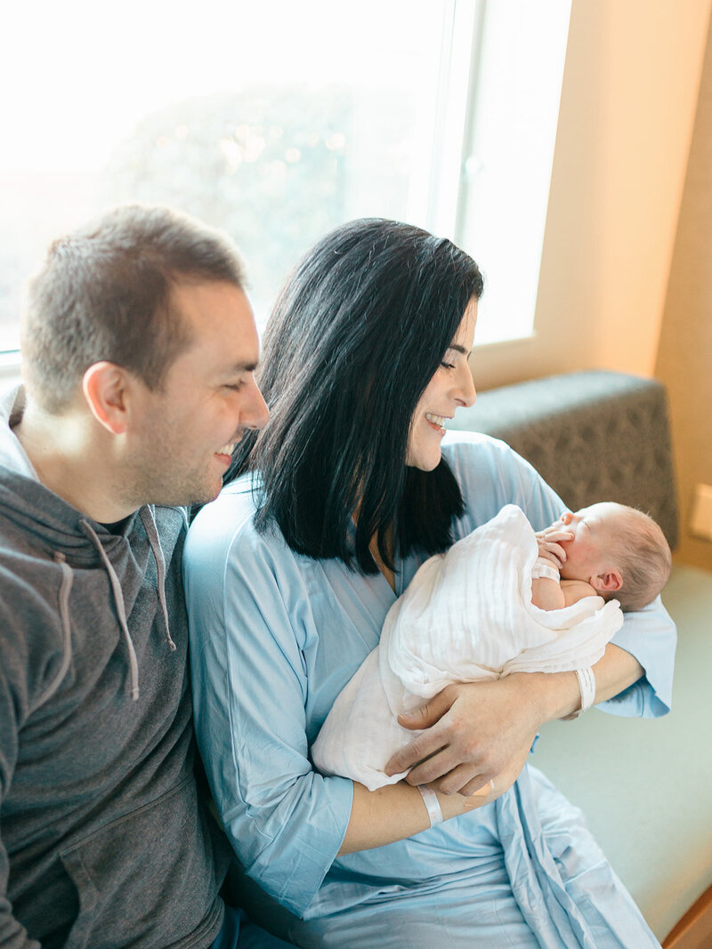 Mom and dad holding newborn baby in hospital
