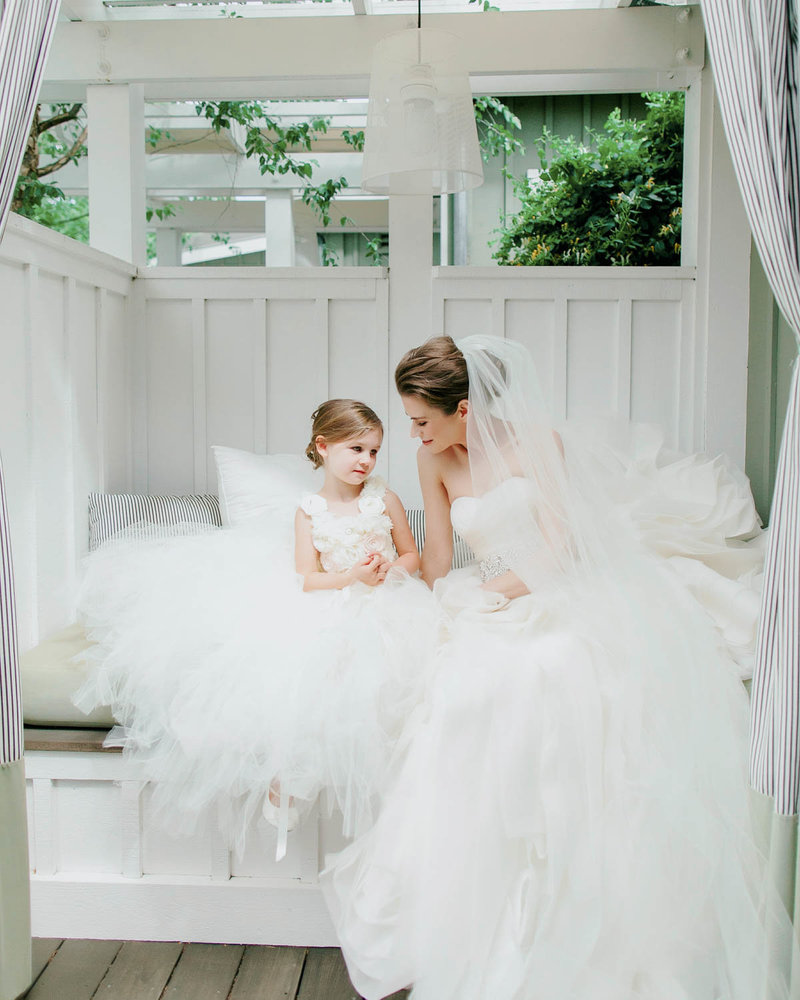 Flower girl sits with Bride on a bench