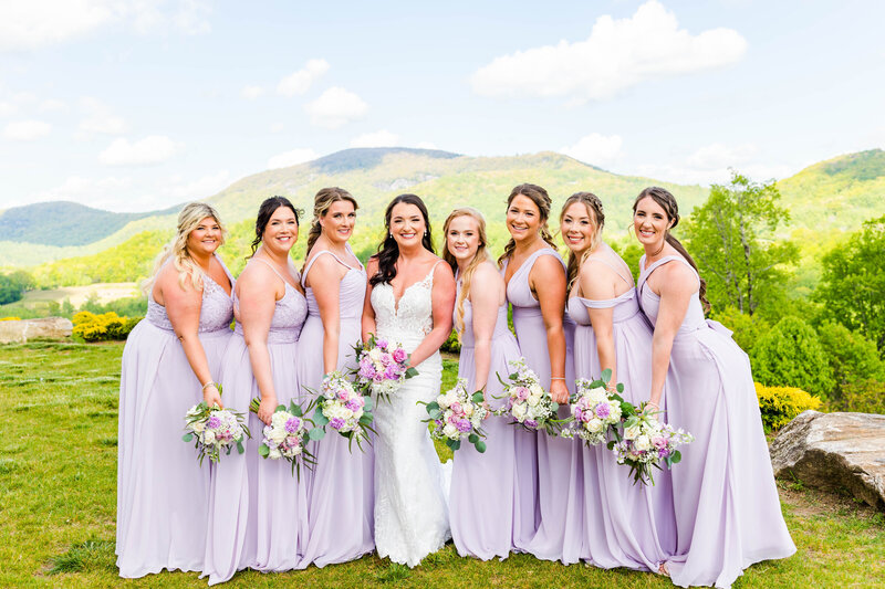 bridesmaids with the bride in purple dresses with purple and white flowers