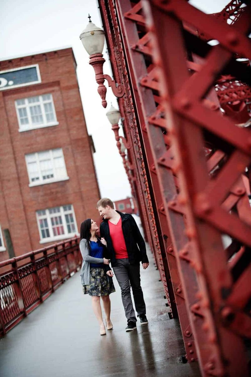 a man and woman walk along the broadway bridge in portland