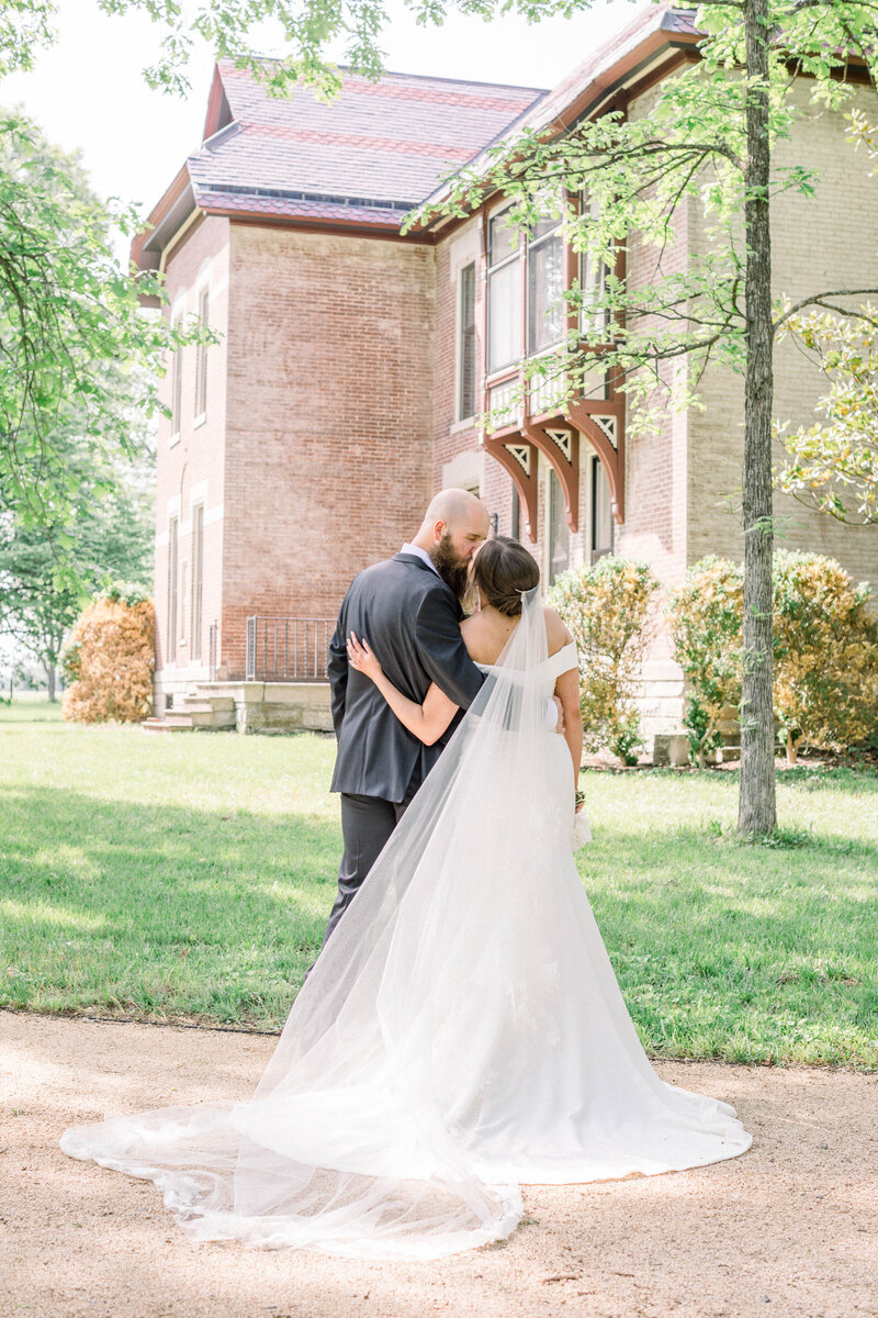 bride and groom kissing in wedding portrait