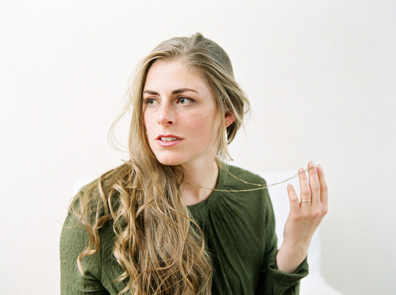 Woman in green blouse looks off into the distance