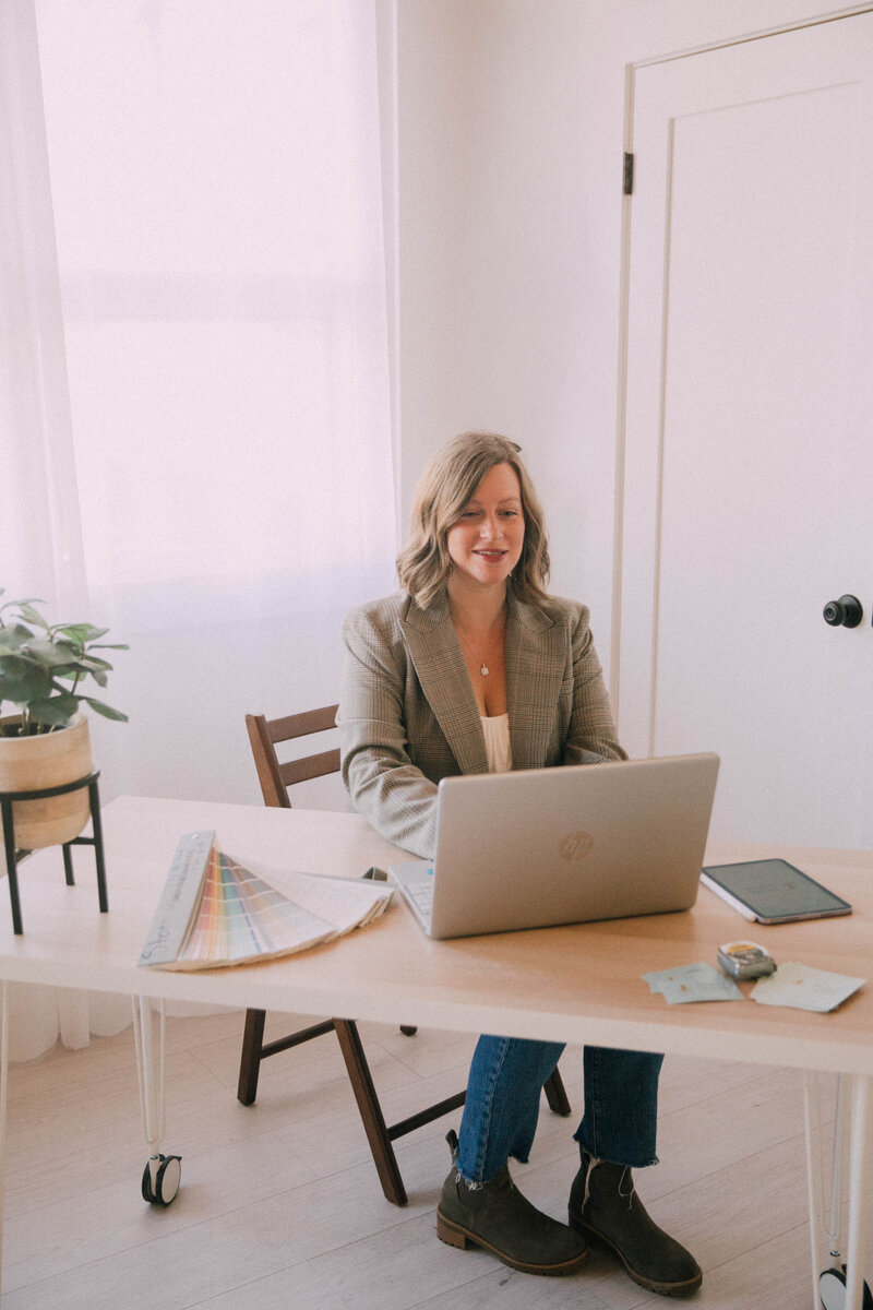 Katie from Modern Mollusk staging a living room in Snohomish County, arranging décor on a coffee table during an occupied home staging project.