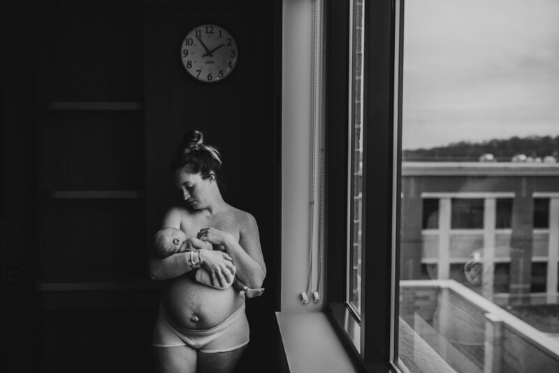 Black and white family session of new mother holding infant