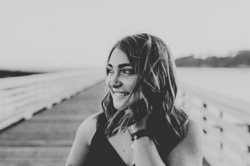 Up close black and white senior photo of girl on the pier