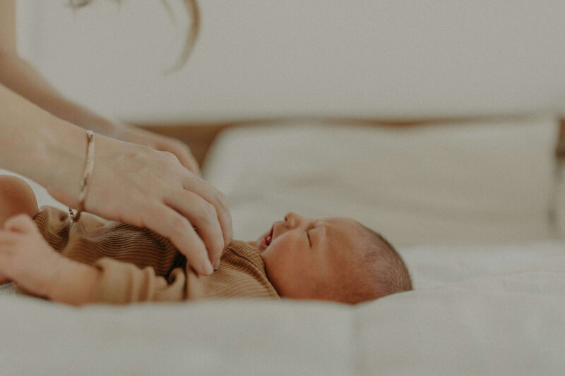 newborn laying on bed