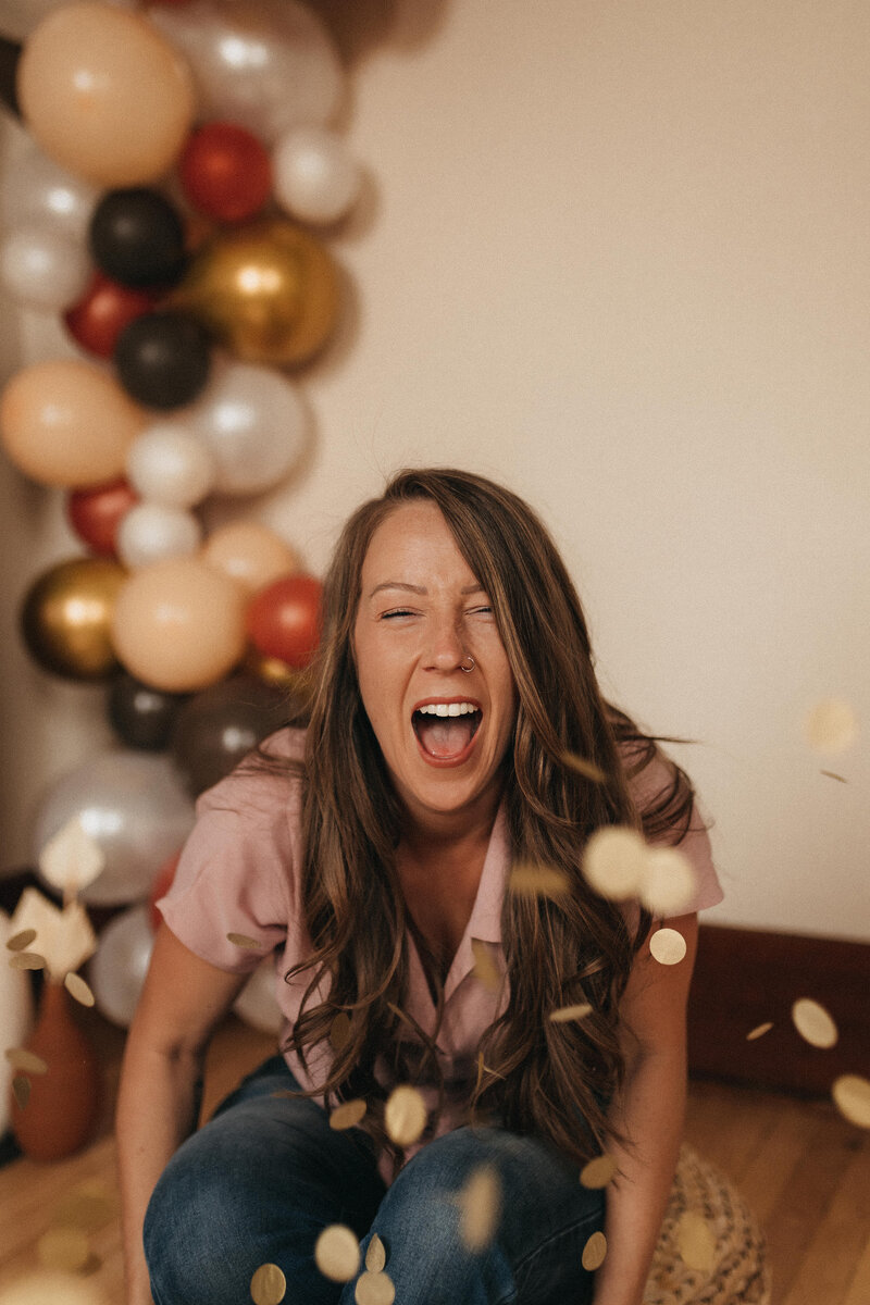 woman sitting in confetti and balloons