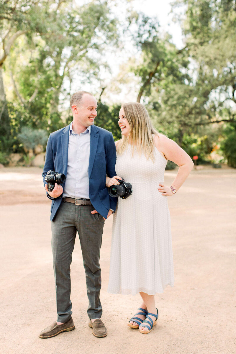 Madison, WI Wedding Photographers, Morgan and Ryan, smiling at each other, holding cameras